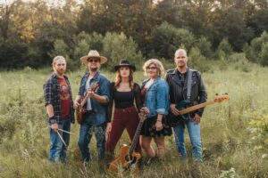 Country Rock band 5 ppl with instruments in a field