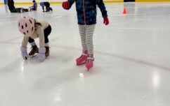 Young person learning to skate on the ice.