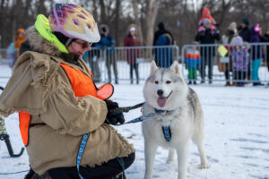Husdy dog with a handler and onlookers at Robert's Yukon Adventure Day at The Grove