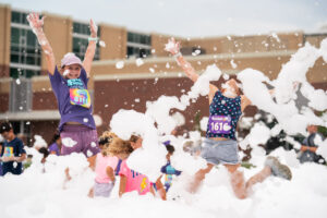 Kids playing in the foam at the 2025 Foam Frenzy Fun Run at Gallery Park.