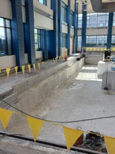 Construction photo of blue pillars and the concrete pool floor at Splash Landings.